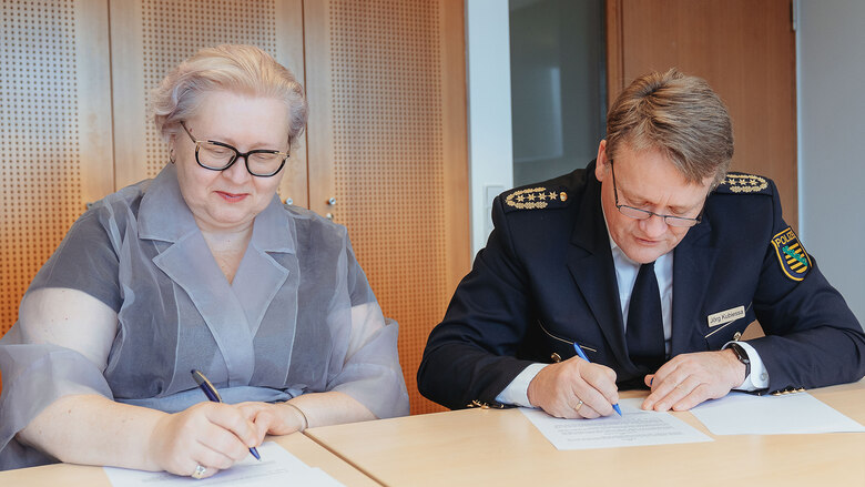 Ekaterina Kulakova, Vorsitzende des Landesverbandes Sachsen der Jüdischen Gemeinden und Landespolizeipräsident Jörg Kubiessa unterzeichnen die Kooperation.