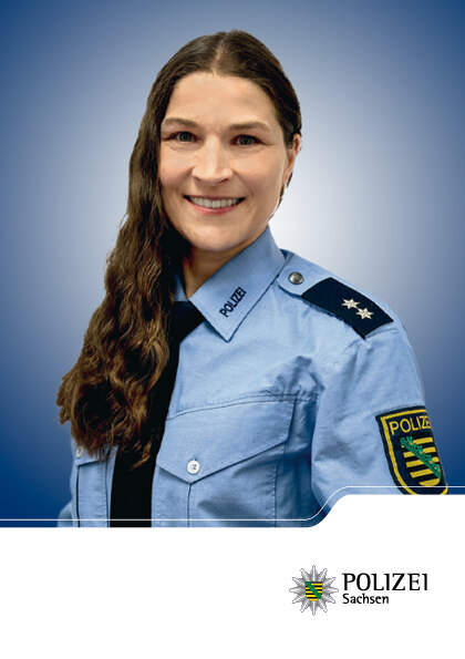 Portrait: Die Frau auf dem Foto hat dunkle Haare. Sie trägt ihre Uniform und schaut in die Kamera.