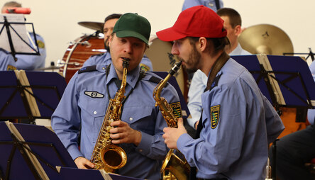 zwei Saxophonspieler mit grüner und roter Mütze