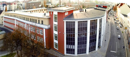 Frontalaufnahme der Polizeidirektion Görlitz. Es handelt sich um ein dreigeschossiges Gebäude mit roter Fassade.