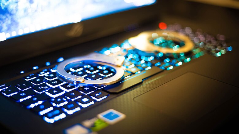 Im Einsatz gegen Kriminalität: Das Themenbild zur Bewerbung für den Vorbereitungsdienst Cybercrime und Wirtschaftskriminalität bei der Polizei Sachsen zeigt Handschellen auf einer Laptop-Tastatur.