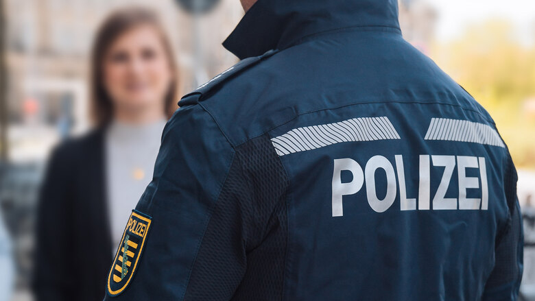 Ein Bürgerpolizist im Gespräch mit einer jungen Frau. Der Bürgerpolizist ist als Polizeibeamter Ansprechpartner für die Menschen vor Ort.