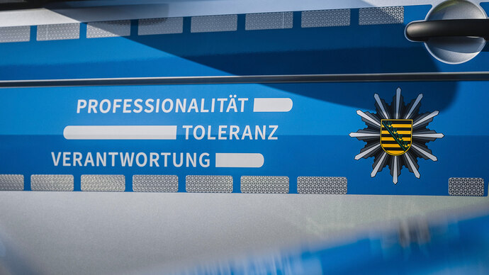Was macht die Polizei Sachsen aus? Das Logo »Professionalität – Toleranz – Verantwortung«, das Leitbild der sächsischen Polizei, gemeinsam mit dem Polizeistern auf einem Einsatzfahrzeug. Das Leitbild definiert Werte, Mission und Vision.