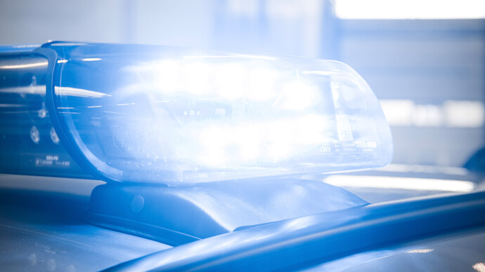 Die Detailaufnahme zeigt ein leuchtendes Blaulicht am Einsatzfahrzeug der Polizei in einer modernen, hellen Garage.