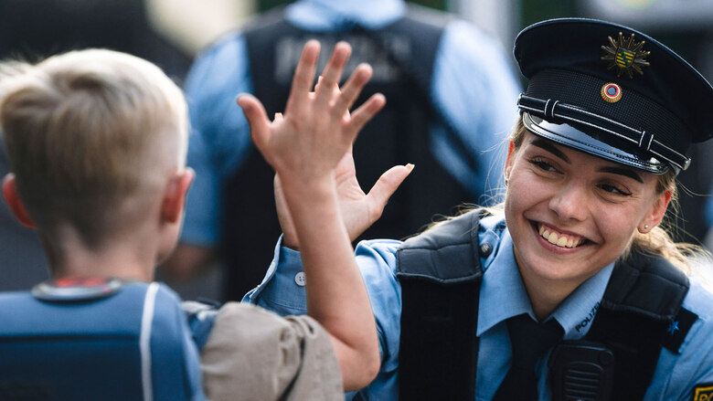 Eine junge Polizistin in Uniform und ein Schulkind mit Schulrucksack: Es gibt viele Veranstaltungen und Termine, bei denen sich die Polizei Sachsen vorstellt oder über ihre Arbeit informiert.