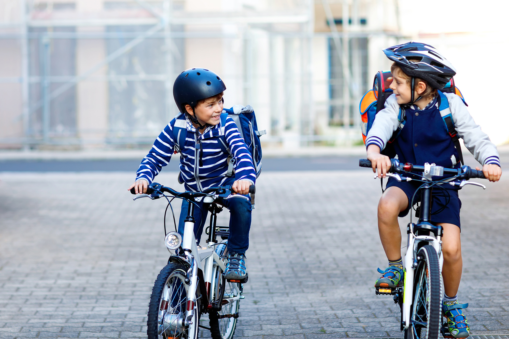 Zwei Jungen mit Helm fahren zusammen Fahrrad