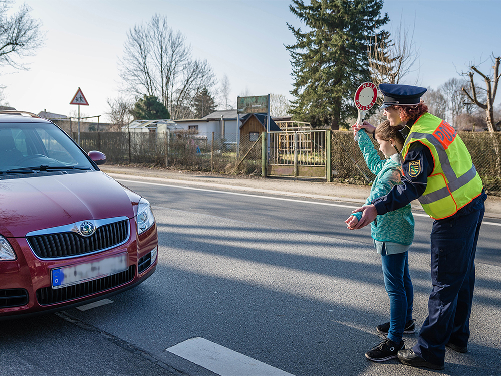 Polizistin und Kind halten Auto an