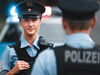 Eine Polizistin vor einem Streifenwagen.