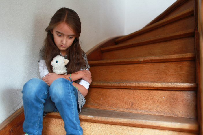 Trauriges Mädchen auf Treppe