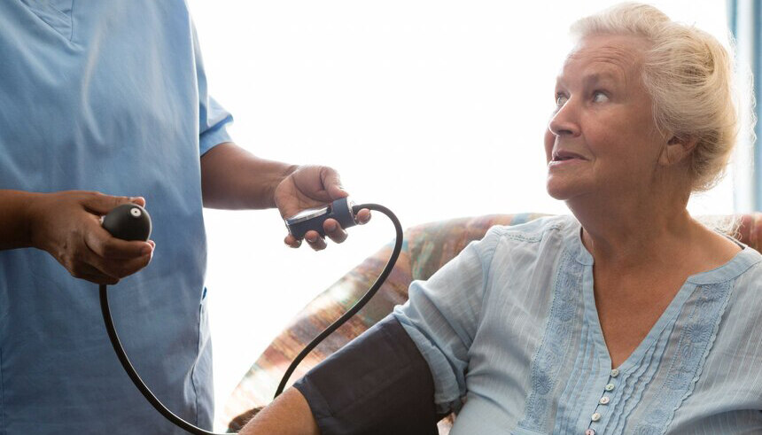 Pfleger mit Patientin beim Blutdruckmessen