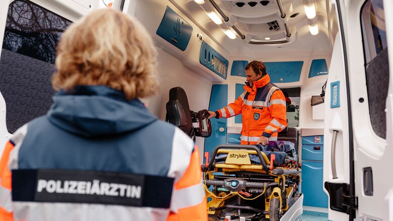 Eine Polizeiärztin und ein Notfallsanitäter in einem modern ausgestatteten Rettungswagen. Sie gehören zum Team des Polizeipräsidiums für Service und IT (PPSI).