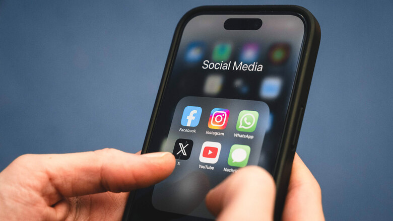 Auf einem Smartphone sind die Icons von Social-Media-Apps wie Facebook, Instagram, WhatsApp, X und YouTube zu sehen.