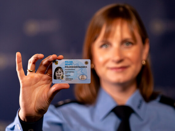 Neu: Der bundeseinheitliche Dienstausweis der Polizei hat Chipkartenform und ist besonders fälschungssicher. Eine Polizistin in Uniform zeigt den Polizeiausweis.