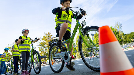 Kinder mit Fahrradhelmen und Warnwesten bei Fahrradübung